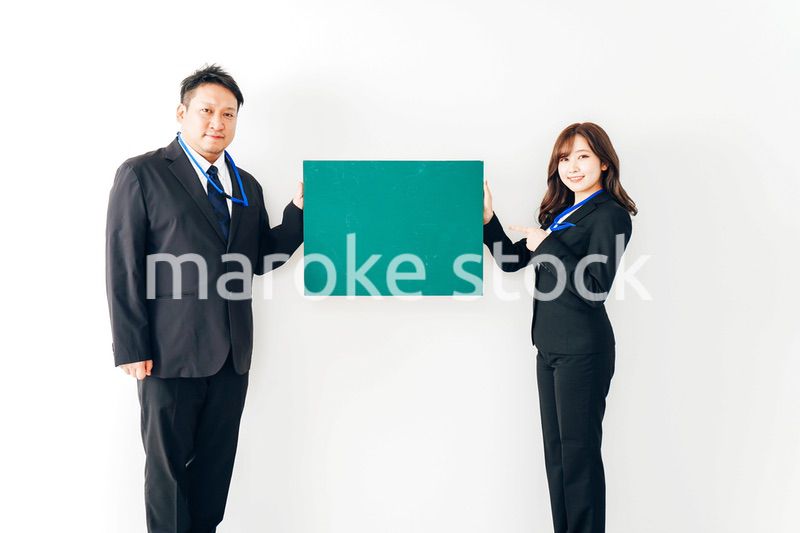 黒板を持つスーツを着た2人のビジネスパーソン