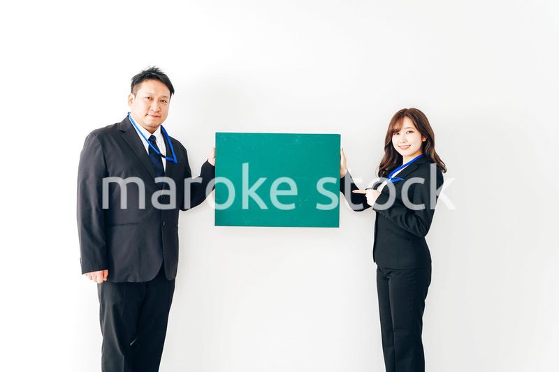 黒板を持つスーツを着た2人のビジネスパーソン
