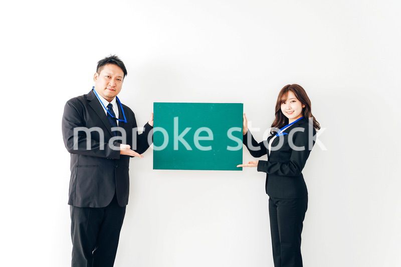 黒板を持つスーツを着た2人のビジネスパーソン