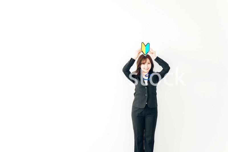 初心者マークを持つスーツを着た若いビジネスウーマン