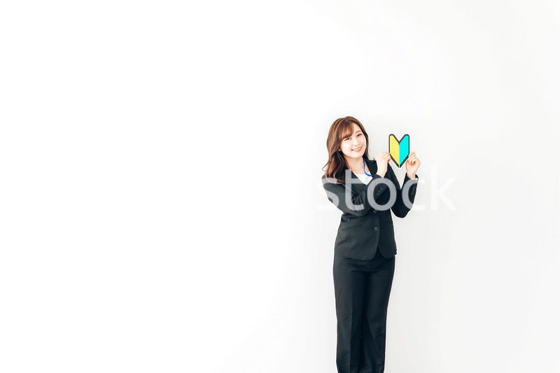 初心者マークを持つスーツを着た若いビジネスウーマン