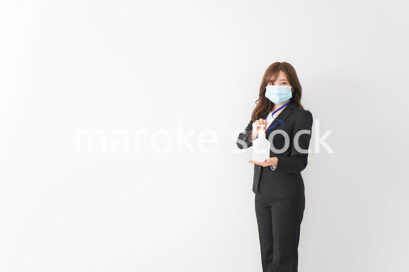 アルコール消毒液を差し出すビジネスウーマン