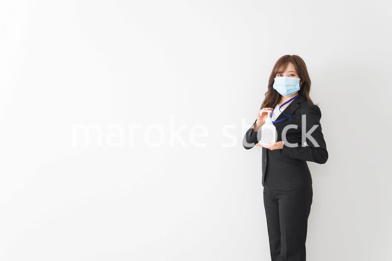 アルコール消毒液を差し出すビジネスウーマン