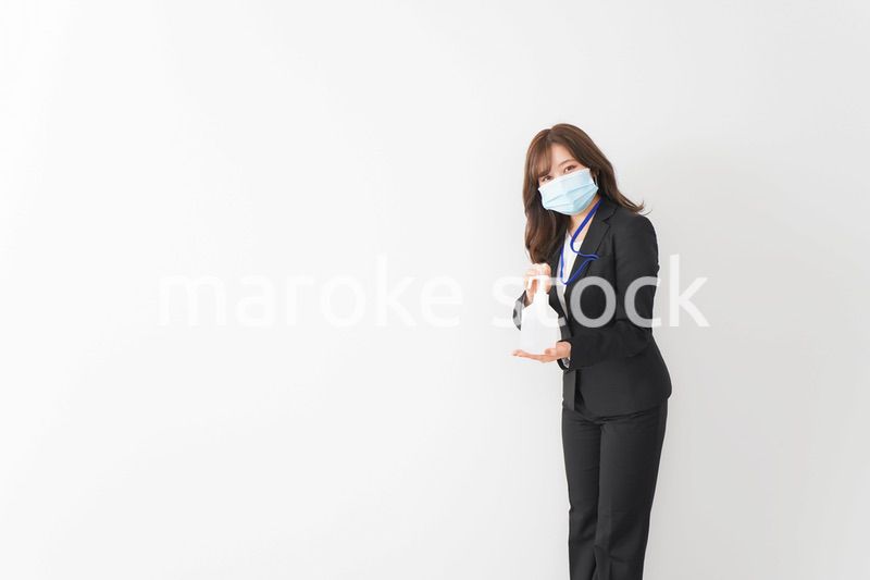 アルコール消毒液を差し出すビジネスウーマン