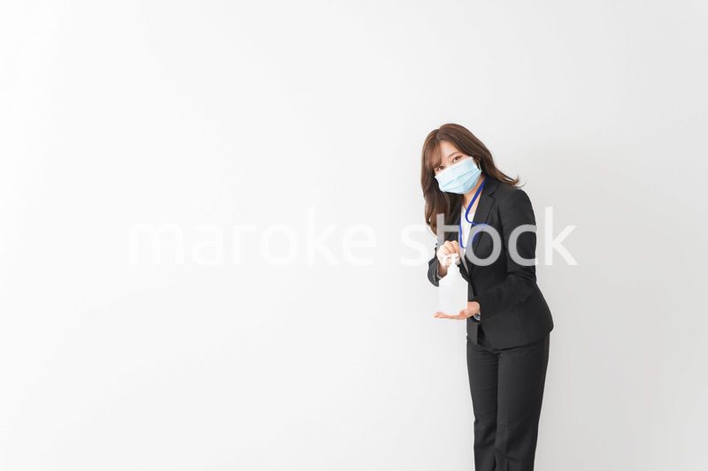 アルコール消毒液を差し出すビジネスウーマン