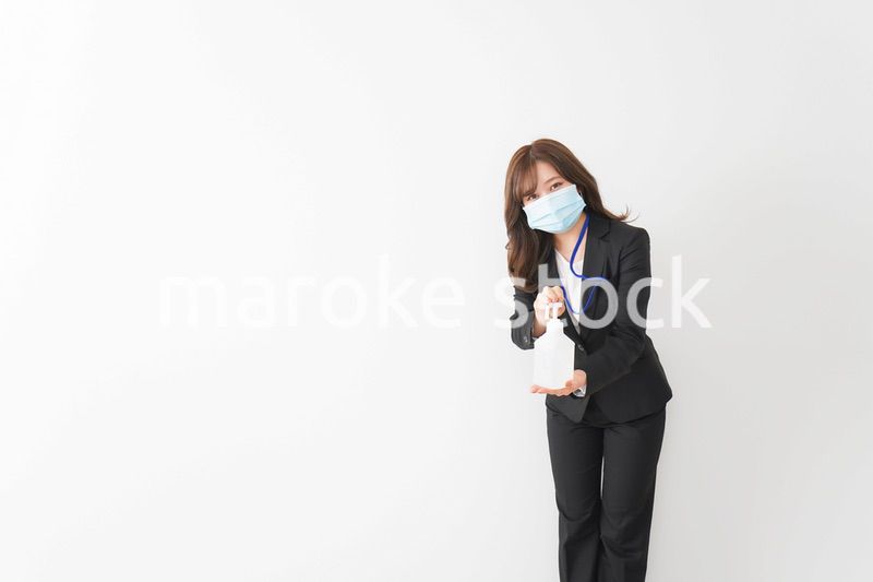 アルコール消毒液を差し出すビジネスウーマン