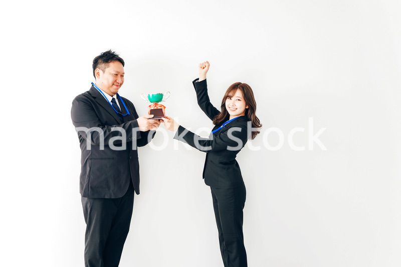 社内表彰で上司からトロフィーをもらうビジネスウーマン