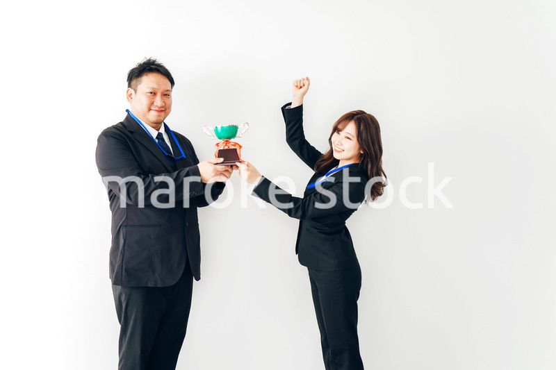 社内表彰で上司からトロフィーをもらうビジネスウーマン