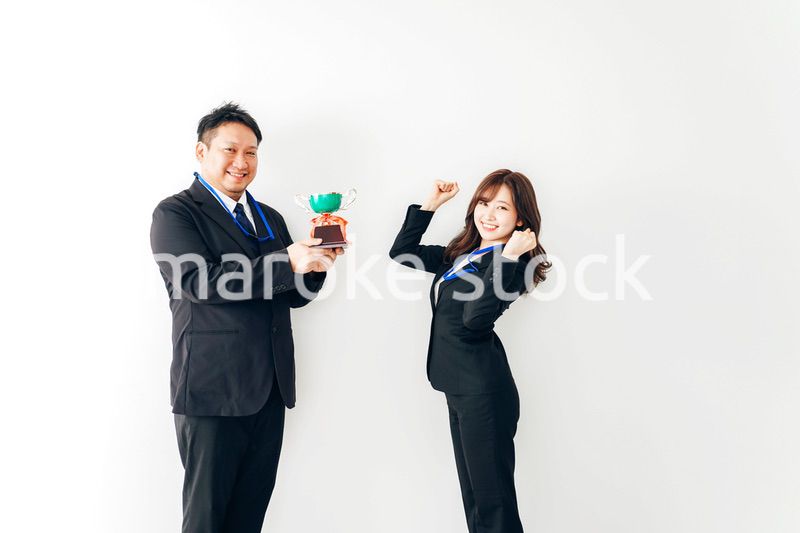 社内表彰で上司からトロフィーをもらうビジネスウーマン