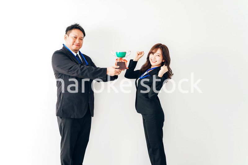 社内表彰で上司からトロフィーをもらうビジネスウーマン