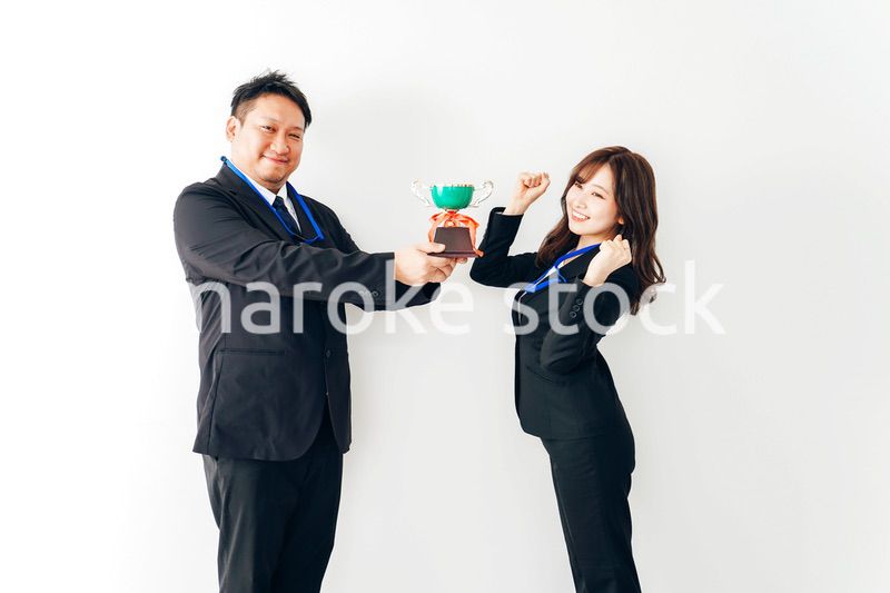社内表彰で上司からトロフィーをもらうビジネスウーマン