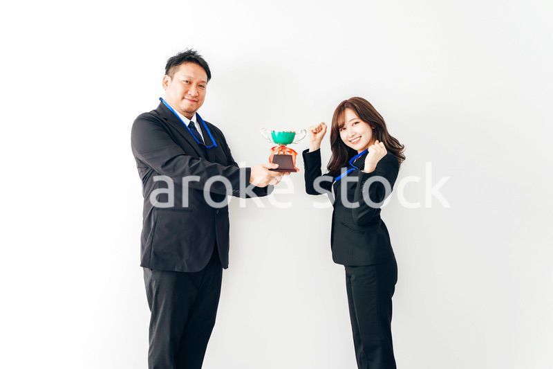 社内表彰で上司からトロフィーをもらうビジネスウーマン