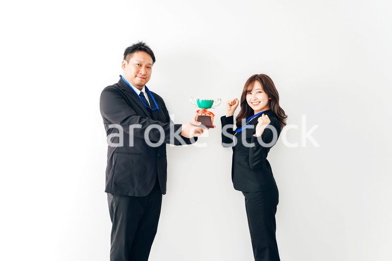 社内表彰で上司からトロフィーをもらうビジネスウーマン