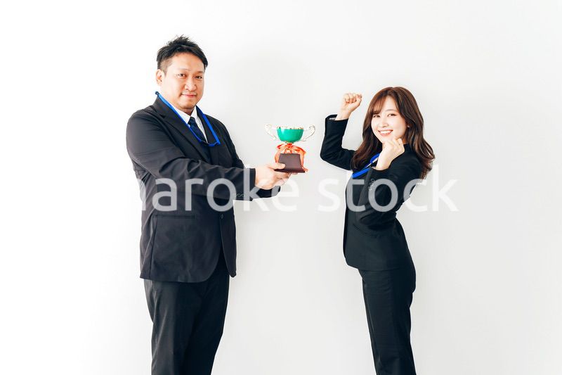 社内表彰で上司からトロフィーをもらうビジネスウーマン