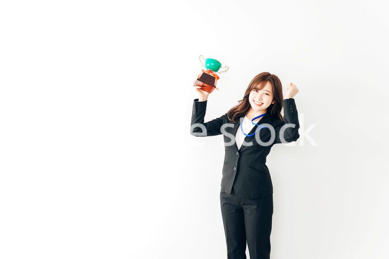 トロフィーを持つ若いビジネスウーマン