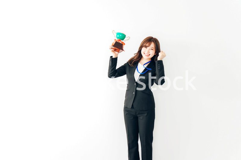 トロフィーを持つ若いビジネスウーマン