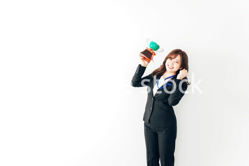 トロフィーを持つ若いビジネスウーマン