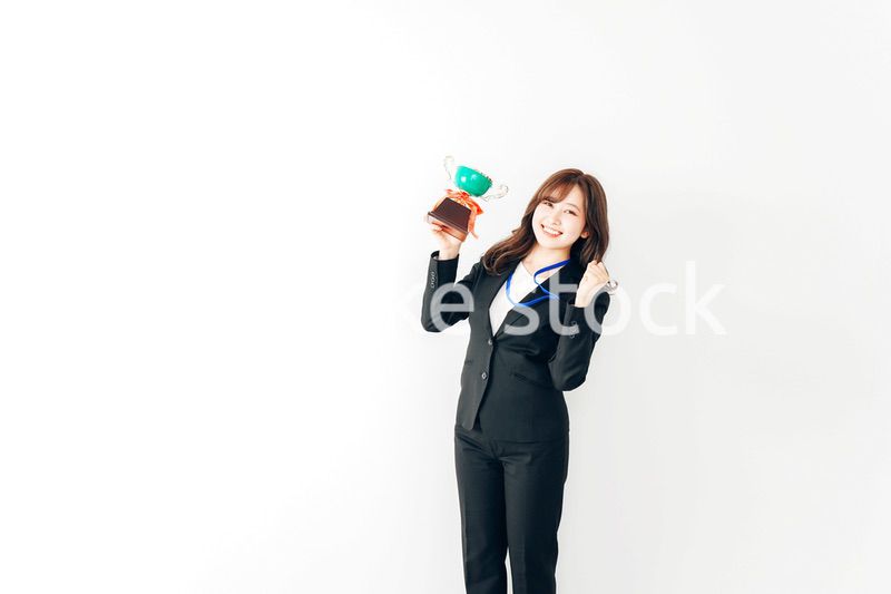 トロフィーを持つ若いビジネスウーマン