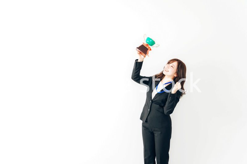 トロフィーを持つ若いビジネスウーマン