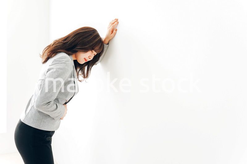 腹痛・生理痛に苦しむ若い女性