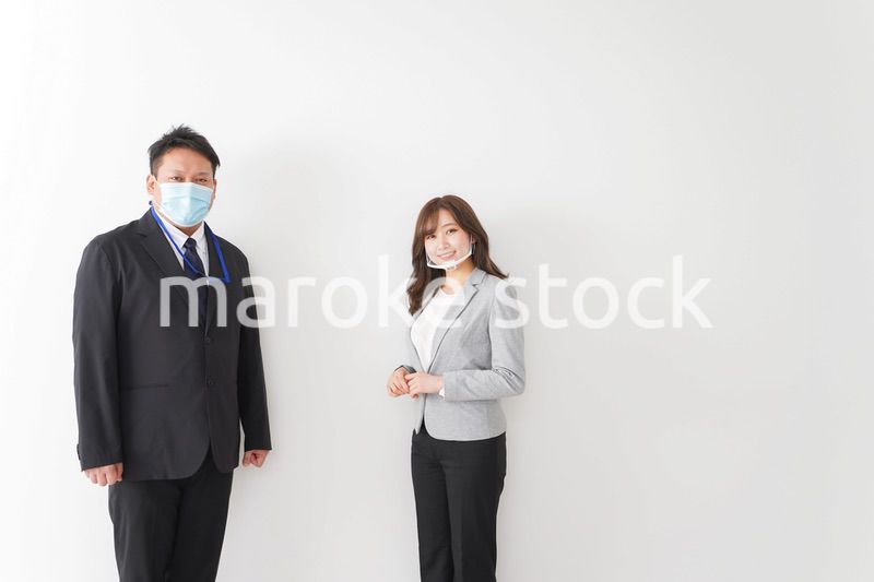 ソーシャルディスタンスを確保し、オフィスで会話をするビジネスパーソン