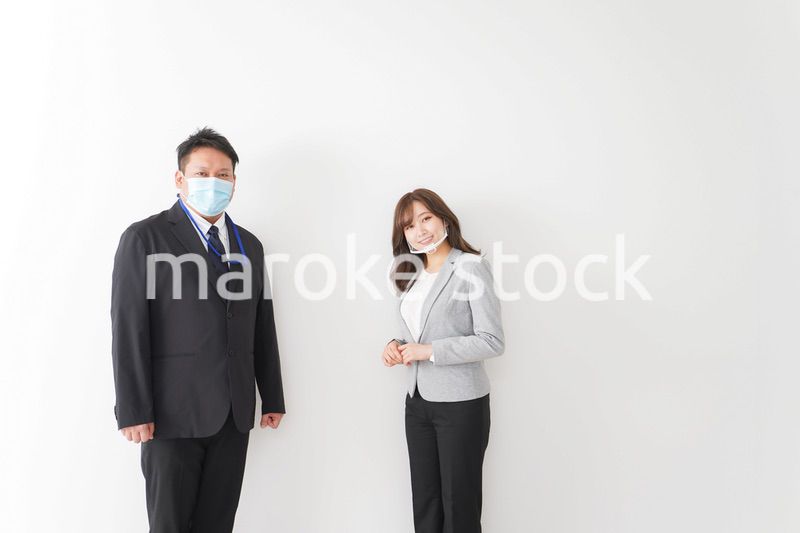 ソーシャルディスタンスを確保し、オフィスで会話をするビジネスパーソン