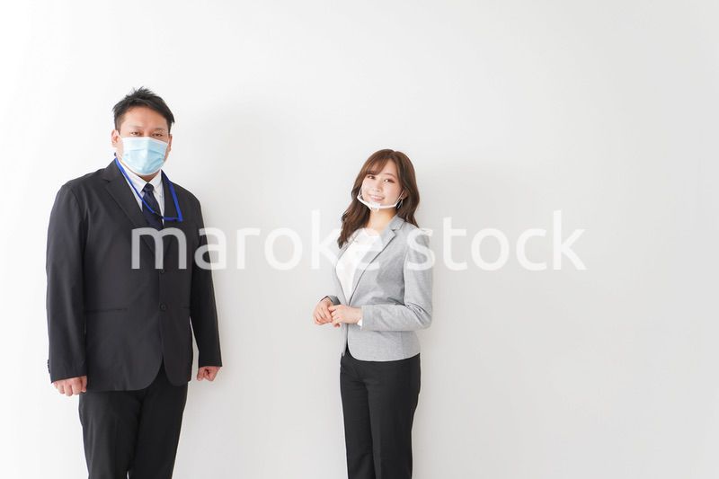 ソーシャルディスタンスを確保し、オフィスで会話をするビジネスパーソン