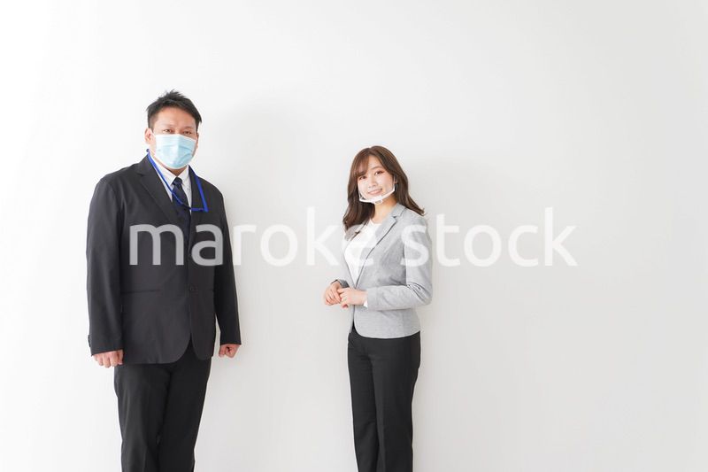 ソーシャルディスタンスを確保し、オフィスで会話をするビジネスパーソン