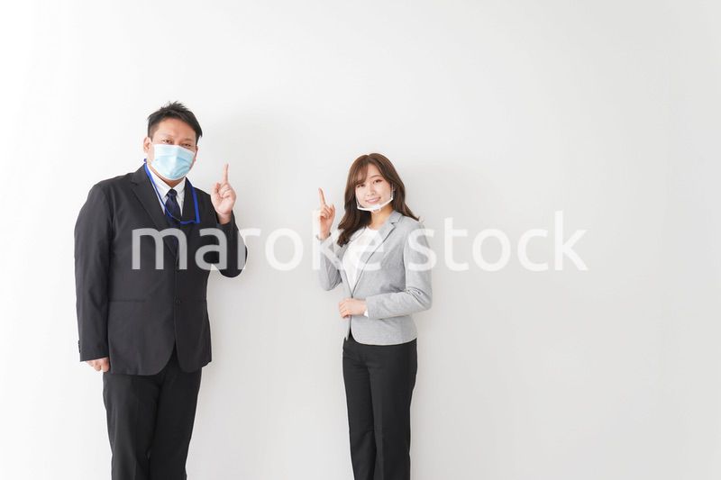 ソーシャルディスタンスを確保し、オフィスで会話をするビジネスパーソン