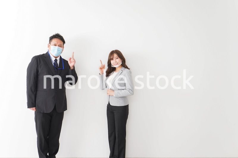 ソーシャルディスタンスを確保し、オフィスで会話をするビジネスパーソン