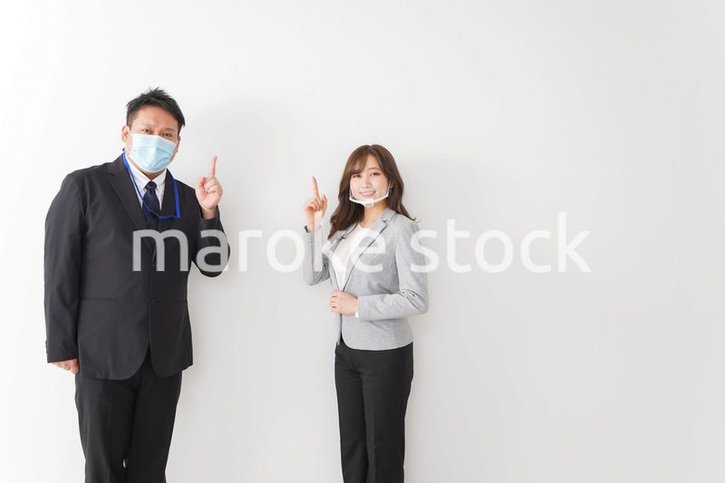 ソーシャルディスタンスを確保し、オフィスで会話をするビジネスパーソン