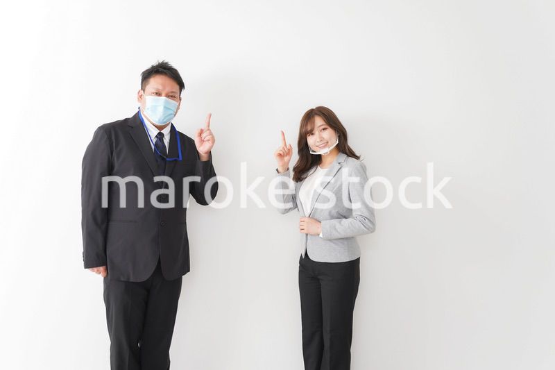 ソーシャルディスタンスを確保し、オフィスで会話をするビジネスパーソン