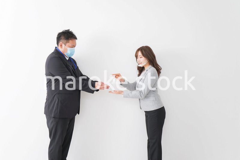 アルコール消毒をお願いするビジネスパーソン