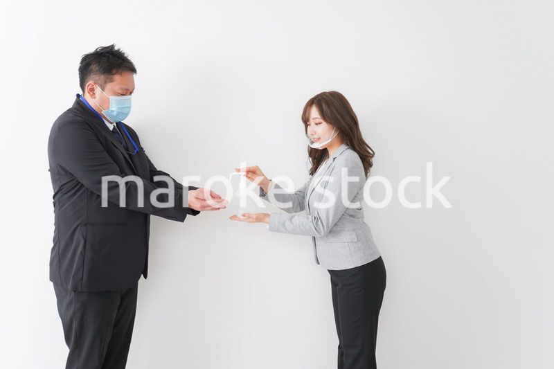 アルコール消毒をお願いするビジネスパーソン