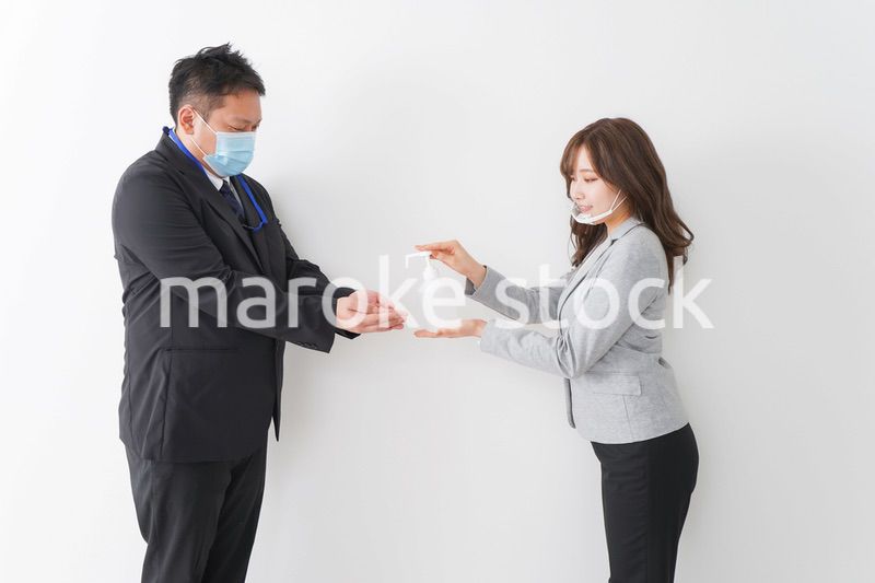 アルコール消毒をお願いするビジネスパーソン