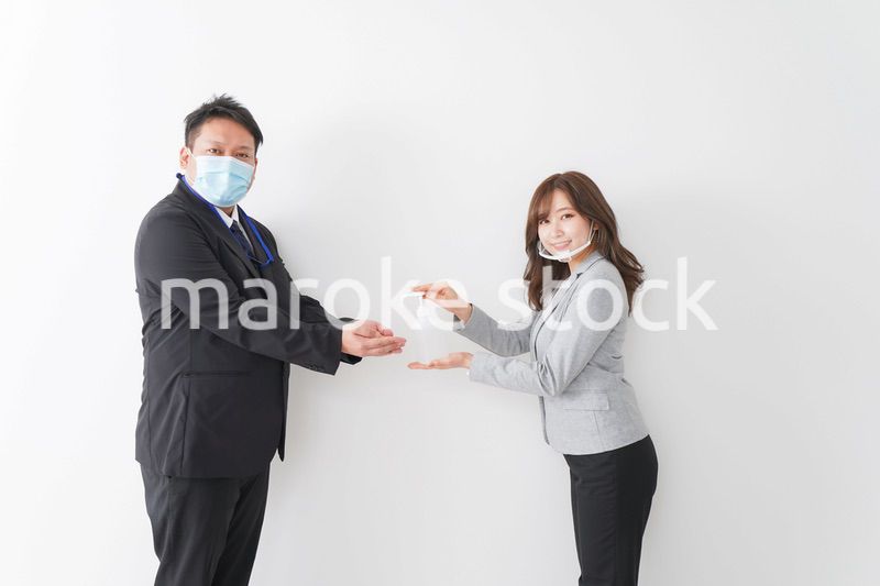 アルコール消毒をお願いするビジネスパーソン