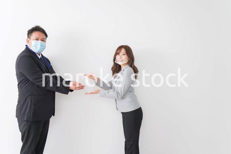 アルコール消毒をお願いするビジネスパーソン