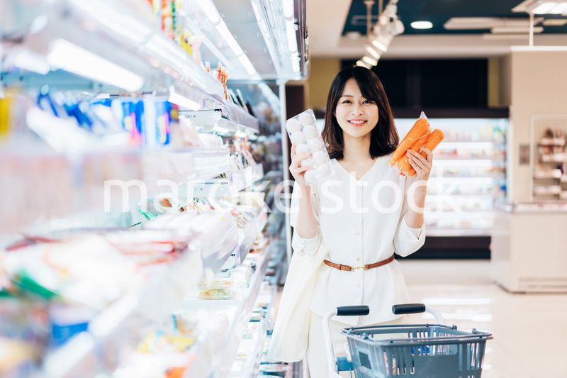 スーパーで食料品を買う若い女性