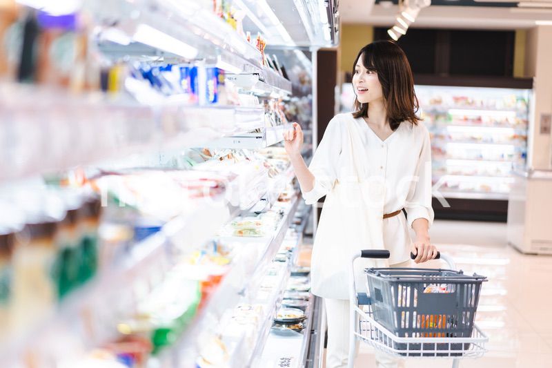 スーパーで食料品を買う若い女性