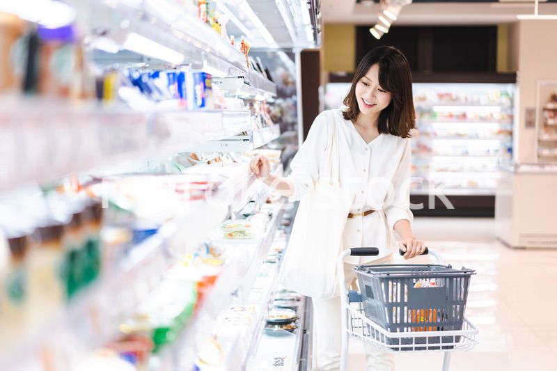 スーパーで食料品を買う若い女性
