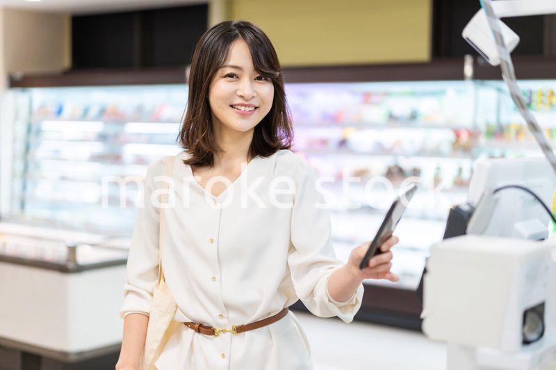 セルフレジ・電子マネー決済をする若い女性
