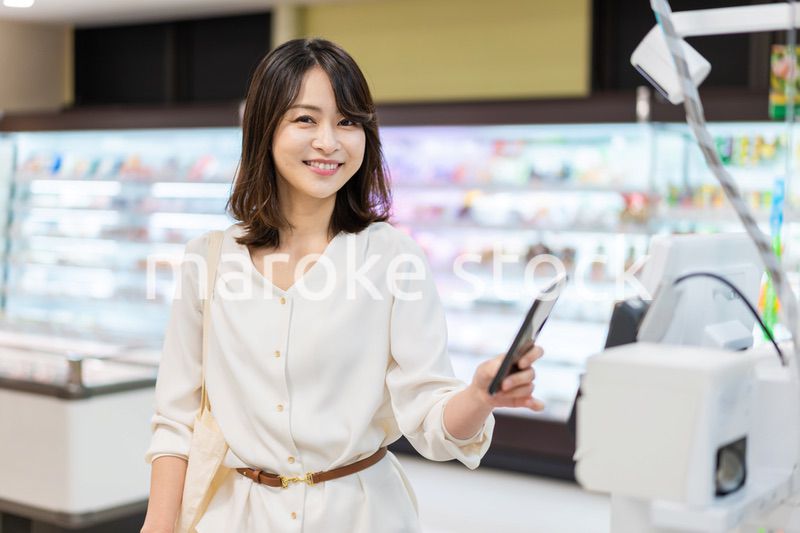 セルフレジ・電子マネー決済をする若い女性