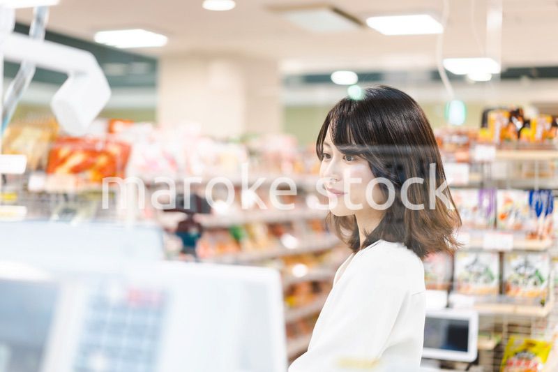 スーパーでスマホ決済を使う若い女性