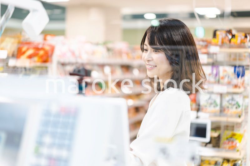 スーパーでスマホ決済を使う若い女性