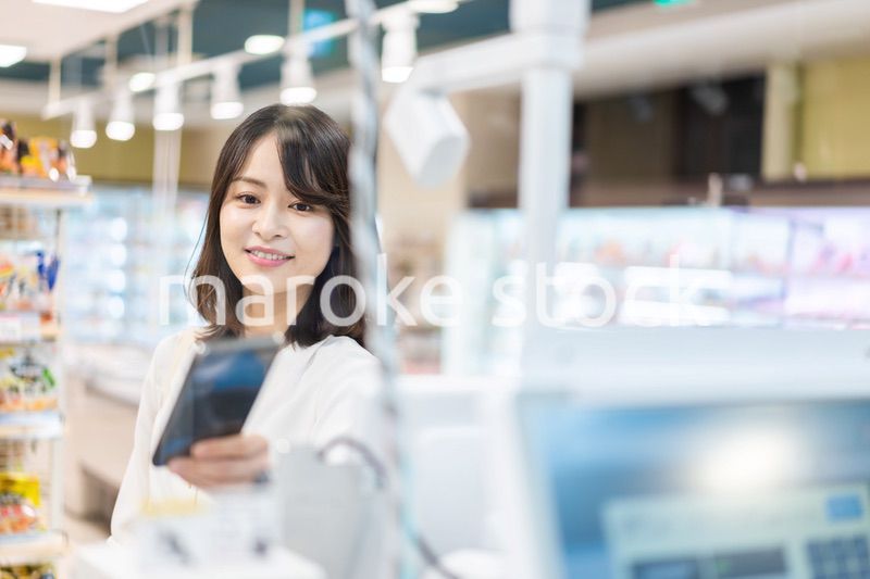 セルフレジ・電子マネー決済をする若い女性