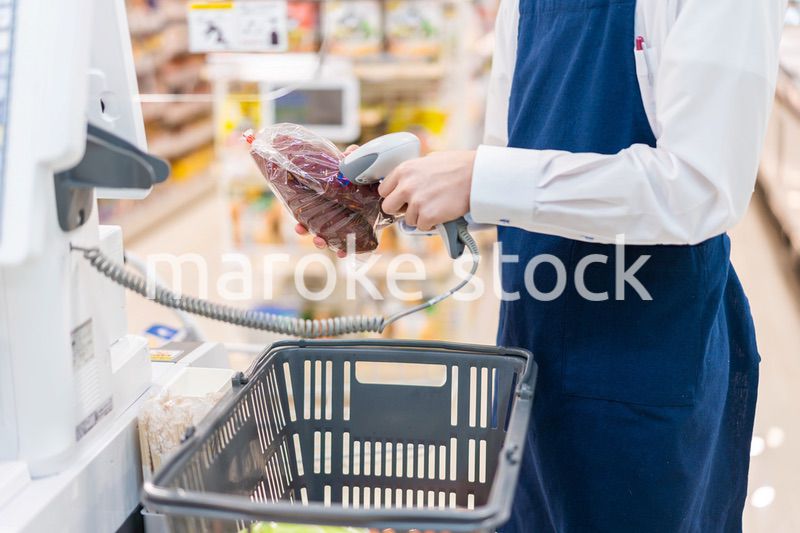 食品スーパーでレジ打ちをするスタッフ