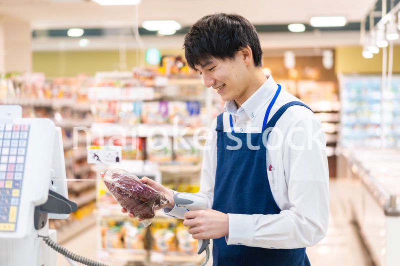 食品スーパーでレジ打ちをするスタッフ