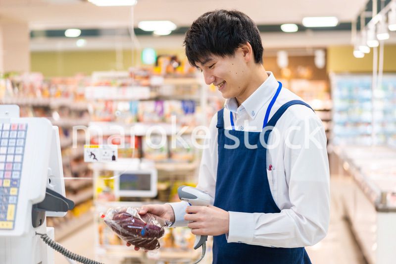 食品スーパーでレジ打ちをするスタッフ