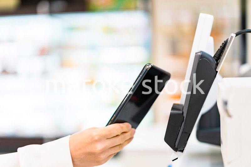スマホ決済で支払う若い女性