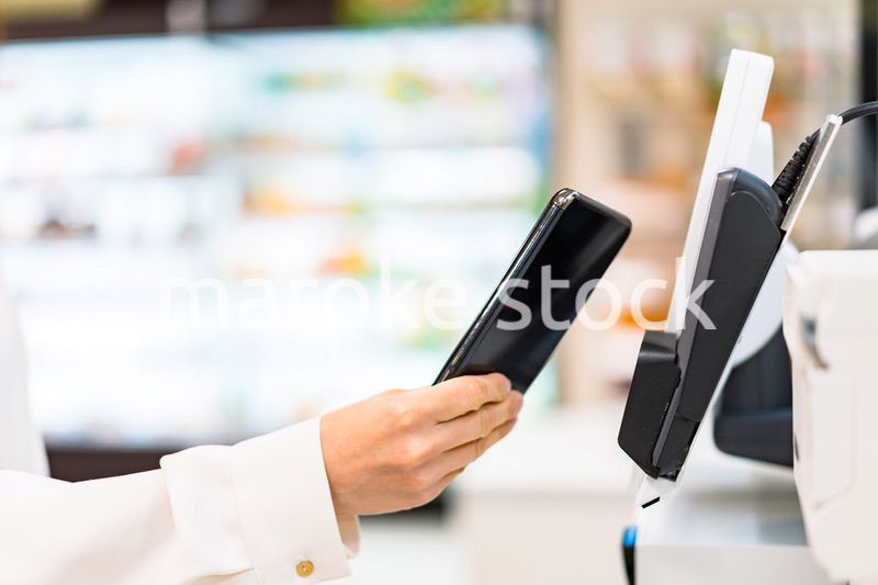 スマホ決済で支払う若い女性